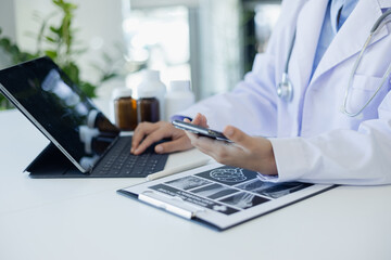 Professional medical doctors woman using smartphone in hospital office. Medicine, healthcare and cardiology concepts.