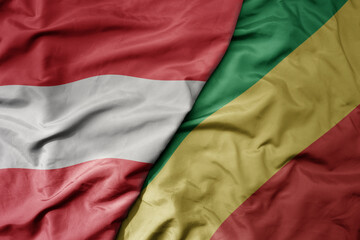 big waving national colorful flag of republic of the congo and national flag of austria .