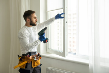 service man installing window with screwdriver