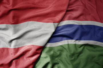 big waving national colorful flag of gambia and national flag of austria .