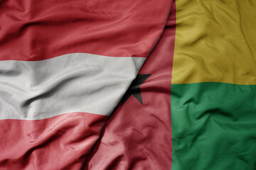 Obraz premium big waving national colorful flag of guinea bissau and national flag of austria .