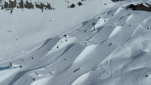 Aerial drone view of Madonna di Campiglio and ursus snowpark in Val Rendena dolomites trentino Italy. Snowboarder skier jumps on kicker in snowpack.
