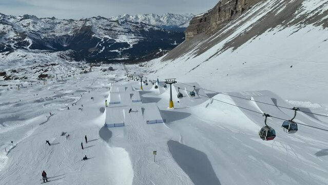Aerial drone view of Madonna di Campiglio and ursus snowpark in Val Rendena dolomites trentino Italy. Snowboarder skier jumps on kicker in snowpack.
