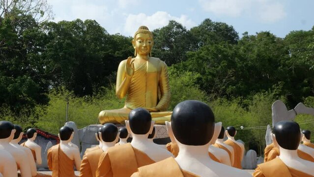Buddha statue giving blessings to many monks statue in Wat Chak Yai Chanthaburi Thailand