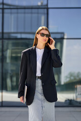 Fototapeta premium A young charming woman working in business calls on the phone and goes to a meeting