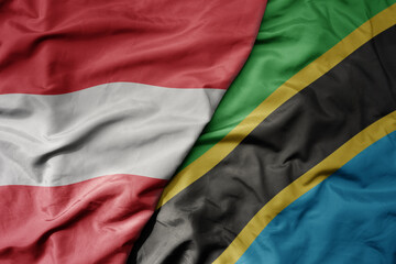 big waving national colorful flag of tanzania and national flag of austria .
