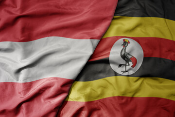 big waving national colorful flag of uganda and national flag of austria .