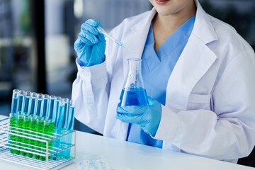 Asian female scientist or medical technician working with a blood lab test in the research lab, Healthcare and medical concept.
