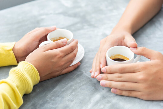 Man and woman holding a cup Sitting on wooden table. Close up man and woman hands, love story concept idea background.