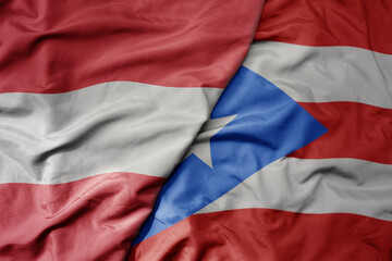 big waving national colorful flag of puerto rico and national flag of austria .