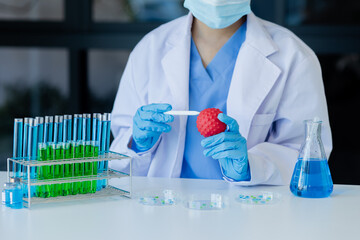 Asian female scientist or medical technician working with a blood lab test in the research lab, Healthcare and medical concept.