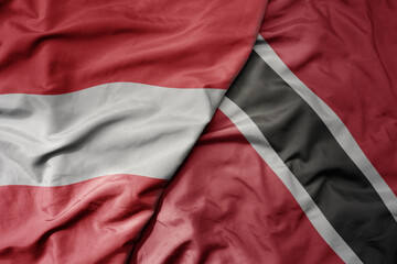 big waving national colorful flag of trinidad and tobago and national flag of austria .