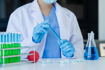 Asian female scientist or medical technician working with a blood lab test in the research lab, Healthcare and medical concept.