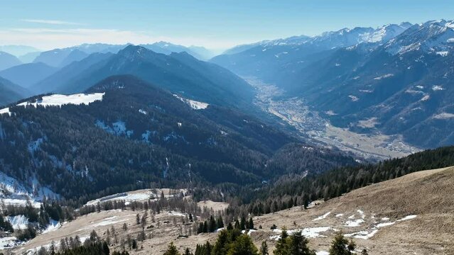 Aerial drone Winter view on dolomites alps in Italy.  Pinzolo in winter sunny day.  Paragliding mountains.
Sitting on bench in dolomites in winter. Val Rendena dolomites  Italian alps, Trentino Italy.