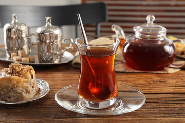 Turkish tea and sweets served in vintage tea set on wooden table