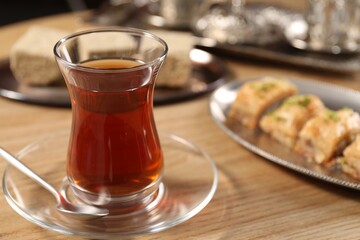 Traditional Turkish tea in glass on wooden table, closeup. Space for text