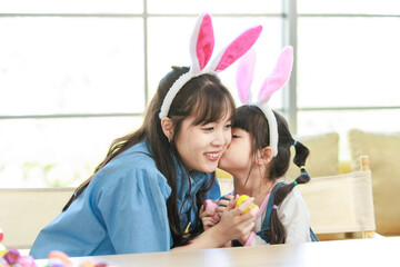 Asian cute little children girl wearing funny bunny ears headbands and young happy mother kiss...