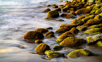 Rocks and stones on a tropical beach in the Caribbean sea. Surf water motion with longtime exposure...