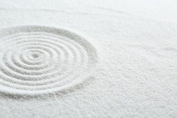 Fototapeta na wymiar Zen rock garden. Circle pattern on white sand, closeup. Space for text