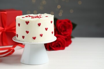 Bento cake, gift box and roses on white wooden table, space for text. St. Valentine's day surprise