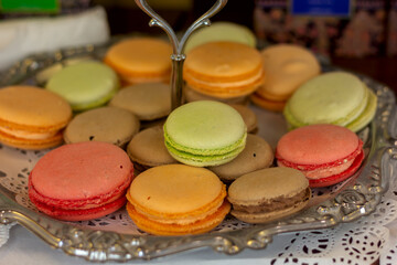 a lot of multi-colored macaron cakes on a candy bowl close-up