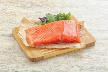 Raw salmon fillet over board