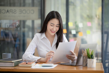 Happy asian young businesswoman holding documents folders in office working space, Asian female...