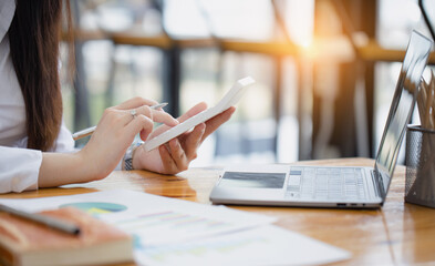 Fototapeta premium Happy asian accounting businesswoman working with calculate in office working space, Asian female employee using laptop at workplace.
