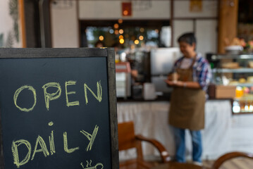 Asian lovely senior, elderly, retired, woman working at her coffee shop. Startup and Small business, Business owner. Selective focus at wood board.