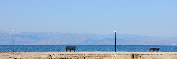 Fototapeta na wymiar Pier with bench on the beach of Corfu Island, Greece.