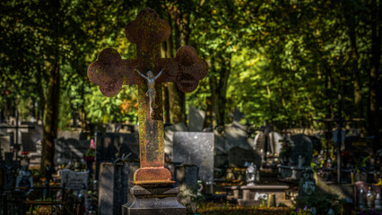 CEMETERY - An old crucifix with a figurine of Jesus on a tombstone