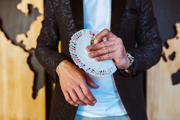 Close up portrait of male magician hands showing tricks with cards.