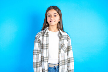 Amazed Young beautiful teen girl wearing check shirt bitting lip and looking tricky to empty space.