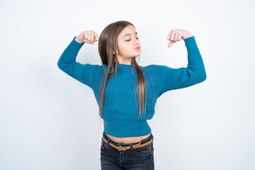 Obraz na płótnie Canvas Young beautiful teen girl wearing blue T-shirt showing arms muscles smiling proud. Fitness concept.