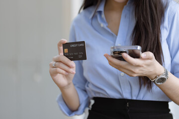 Young asian businesswoman using a credit card with smartphone at at office, Happy shopping online and credit card concept.