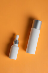 Cosmetic product in tube, bottle, lotion or serum seed on cream background. 