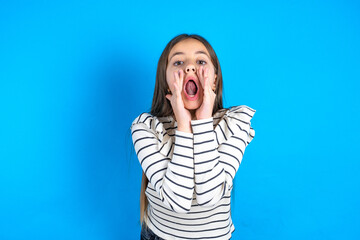Young beautiful teen girl wearing striped T-shirt shouting excited to front.