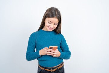 Excited Young beautiful teen girl wearing blue T-shirt winking and eye hold smart phone use read...