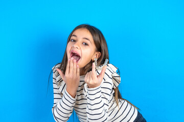 Happy Young beautiful teen girl wearing striped T-shirt holding and showing at camera an invisible aligner while laughing. Dental healthcare and confidence concept.