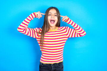 Photo of crazy Young kid girl wearing striped t-shirt screaming and pointing with fingers at hair...