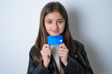 Photo of cheerful Young beautiful teen girl wearing biker jacket hold debit card look empty space