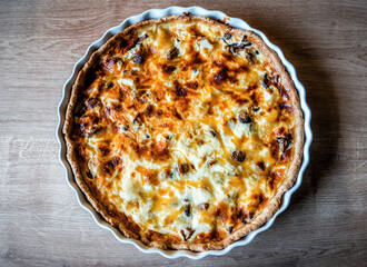 Homemade quiche pie with mushrooms (champignons) and cheese on the table. Savory tart pie with mushrooms.