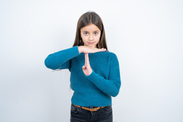 beautiful kid girl wearing blue sweater being upset showing a timeout gesture, needs stop, asks...