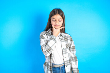 Beautiful kid girl wearing plaid shirt Thinking worried about a question, concerned and nervous with hand on chin.