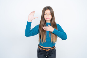 beautiful kid girl wearing blue sweater Swearing with hand on chest and open palm, making a loyalty promise oath