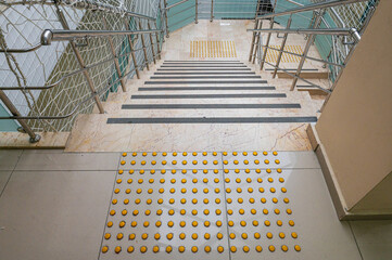 Yellow concrete cobblestones on walkway for blindness people