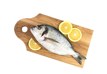 Raw fish Dorado with lemon on a wooden board isolated on a white background. Top view.