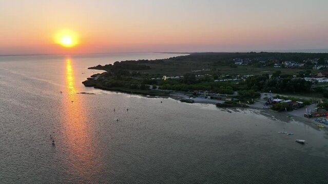 Aerial view of sunset in Hel penisula Jastarnia Puck Bay Baltic Sea. Kitesurfing at sunset. Windsurfing at sunset. Water sports at sunset on sea.