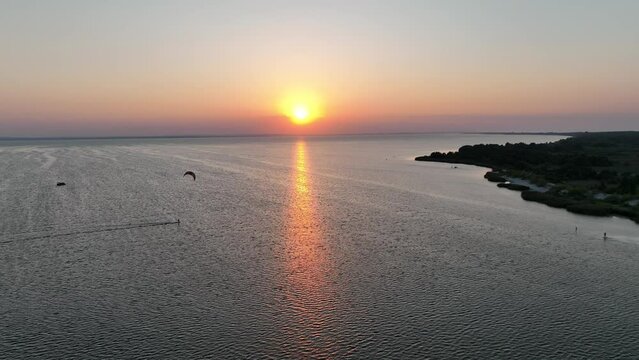 Aerial view of sunset in Hel penisula Jastarnia Puck Bay Baltic Sea. Kitesurfing at sunset. Windsurfing at sunset. Water sports at sunset on sea.