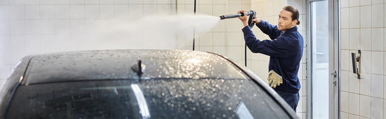 attractive dedicated specialist in blue uniform with collected hair washing carefully black car
